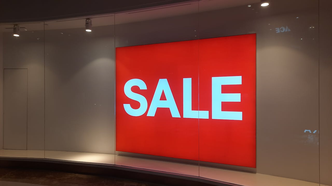 Bright red sale sign in storefront display in Jakarta mall, Indonesia.
